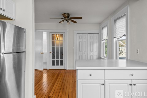 A kitchen with white cabinets and a silver refrigerator.