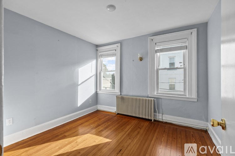 A room with wooden floors and a window with a view of the outside.