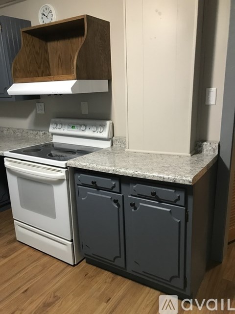 A kitchen with a white stove top oven and a white dishwasher.