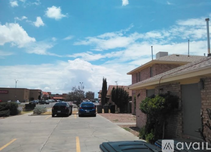 A parking lot with cars and a building in the background.