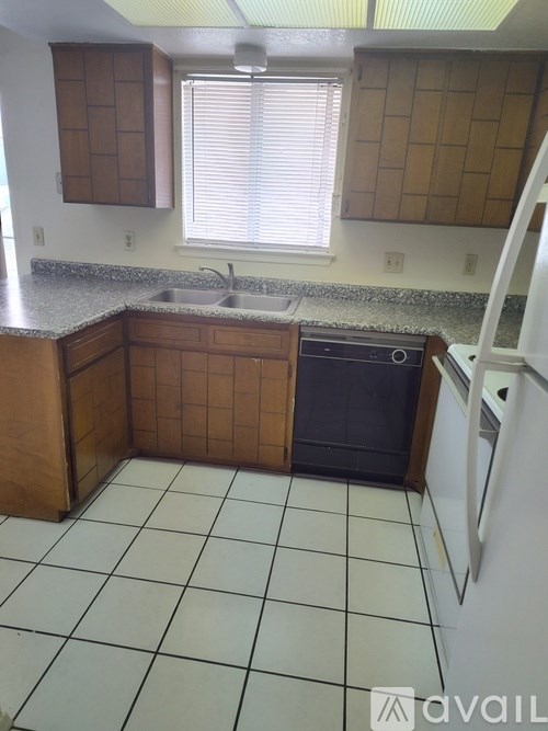 A kitchen with a sink and a refrigerator.