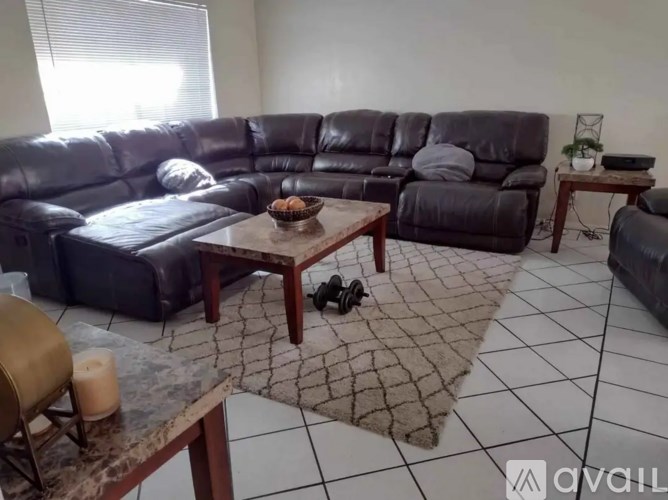 A black leather sofa with a wooden coffee table in front of it.