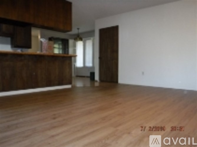 A room with wooden floors and a brown door.