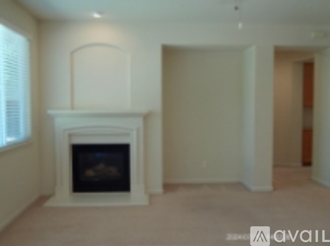 A living room with a fireplace and a window.