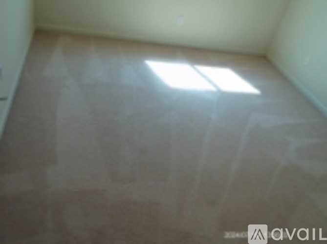 A room with a window and a wooden floor.