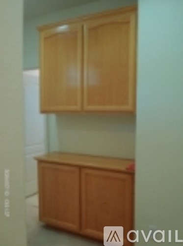 A wooden cabinet with two doors and a shelf underneath it.