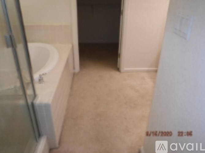 A bathroom with a glass shower door and a white bathtub.