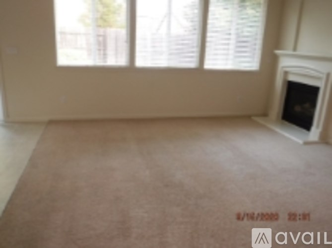 A room with a fireplace and a window with blinds.