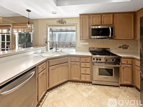 A kitchen with wooden cabinets and stainless steel appliances.