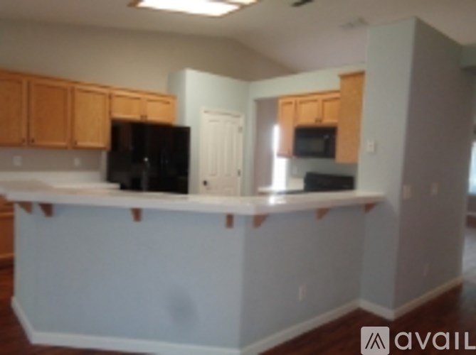 A kitchen with a white counter top and wooden cabinets.