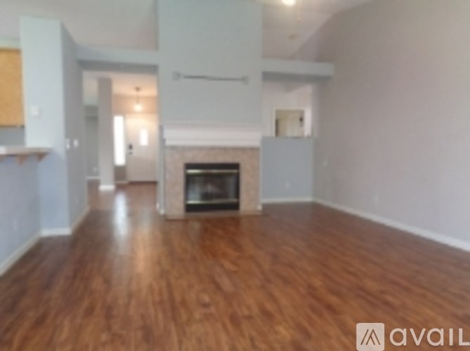 A living room with a fireplace and wood floors.