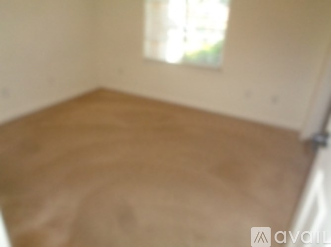 A room with a window and wooden floor.