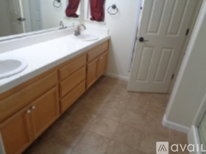 A bathroom with a sink, mirror, and wooden cabinets.