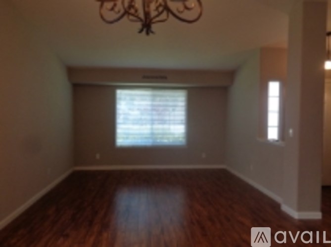 A room with wooden floors and a chandelier.