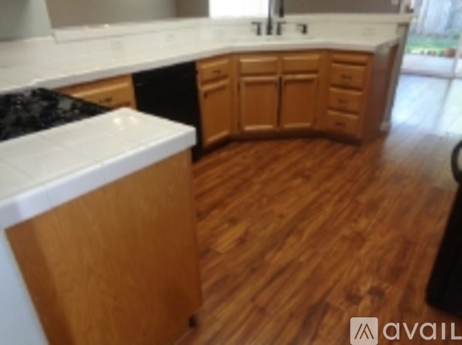 A kitchen with wooden floors and cabinets.