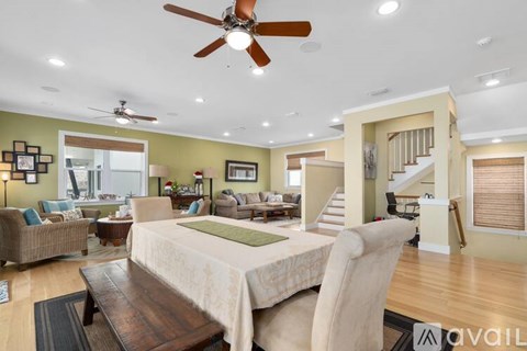 A spacious living room with a dining table and chairs.