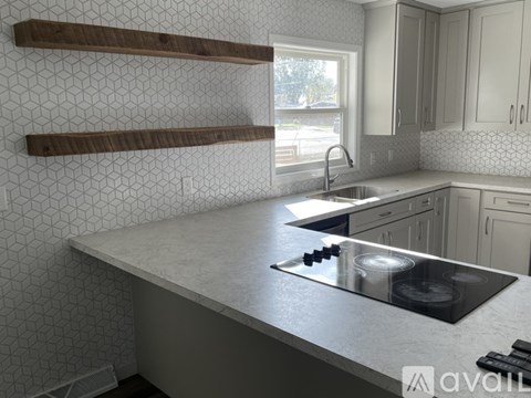 A kitchen with a white countertop and a black stove top.
