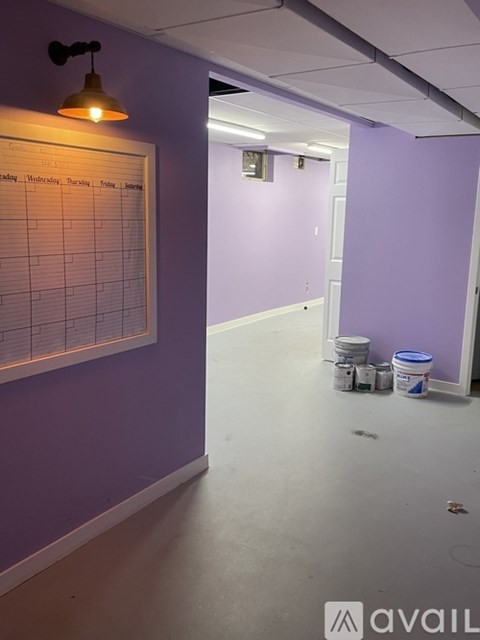 A white calendar hangs on a purple wall.