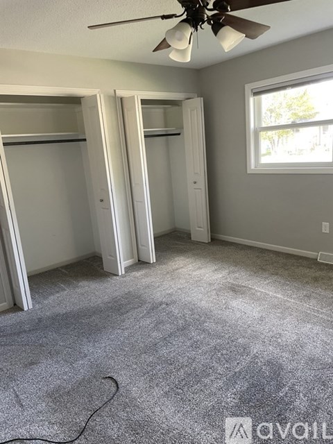 A room with a ceiling fan and a window.