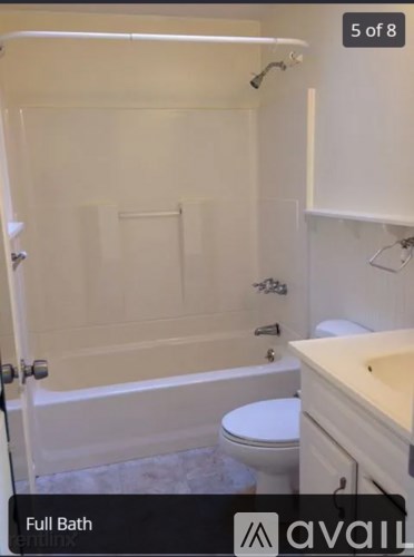 A white bathroom with a toilet and a bathtub.