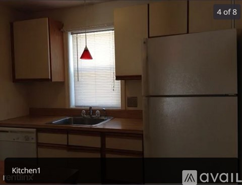 A kitchen with a sink and a window with blinds.