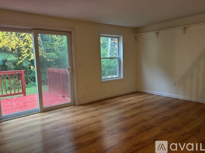 A hallway with a door on the left and a wall on the right.