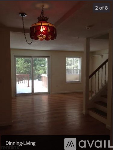 A living room with a chandelier and a staircase.