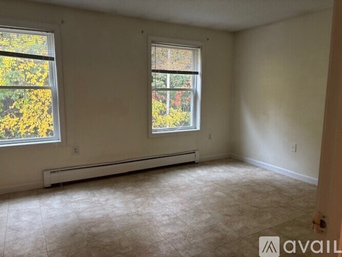 A room with a window and a wall heater.