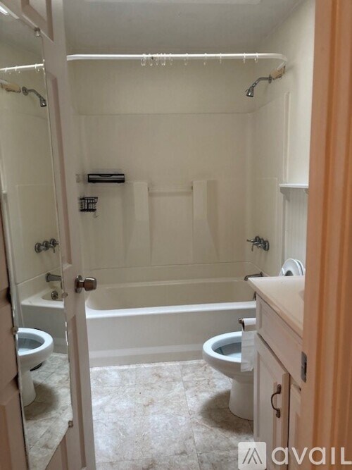 A bathroom with a tub, toilet and sink.