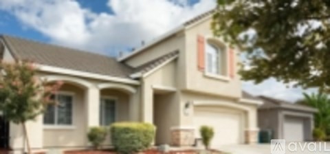 A house with a brown roof and a white wall is available for sale.