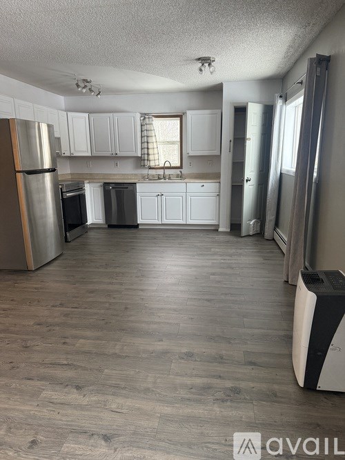 A kitchen with a refrigerator, oven, and sink.