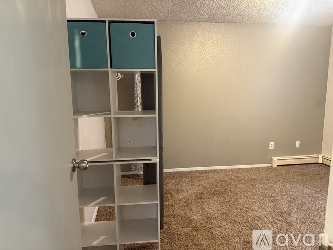 A room with a white door and a grey wall.