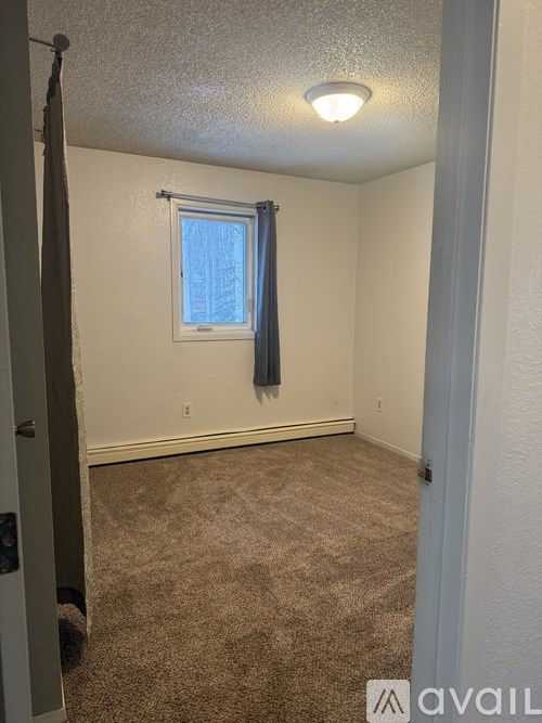 A room with a carpeted floor and a small window.