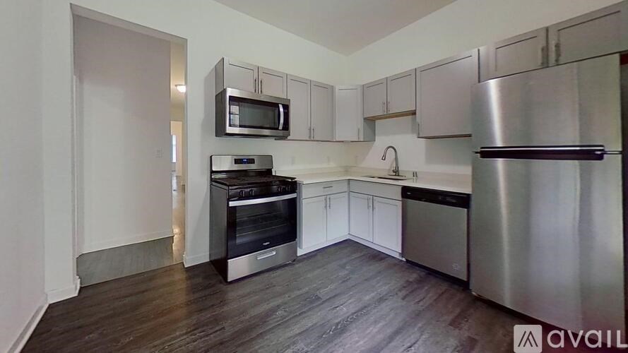 A kitchen with stainless steel appliances and white cabinets.