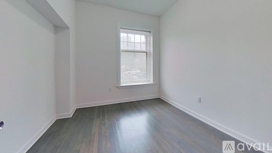 A room with a window and wooden flooring is available for rent.