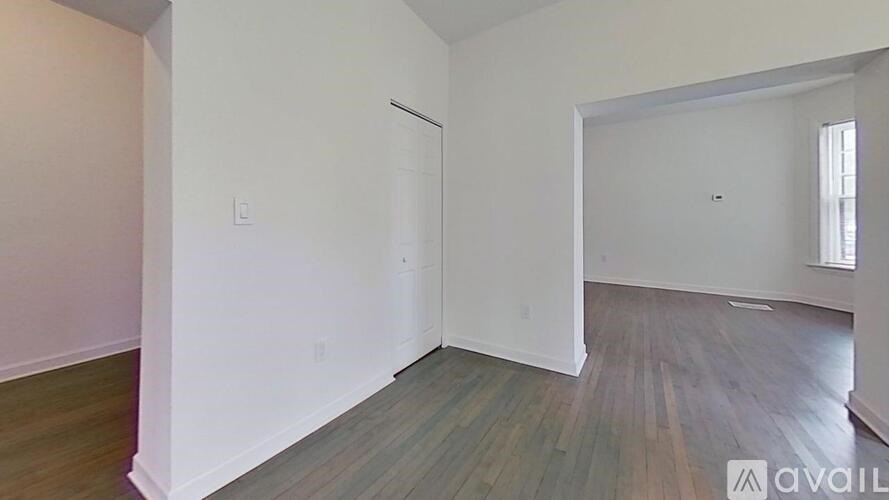 A room with wooden flooring and white walls is available for rent.