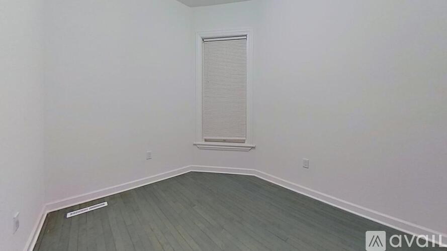 A room with a window and wooden flooring.