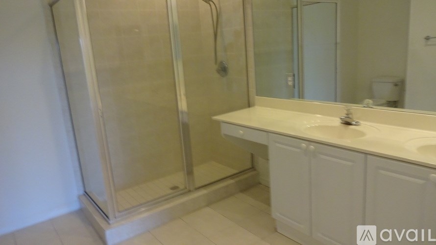 A bathroom with a sink, mirror, and shower.