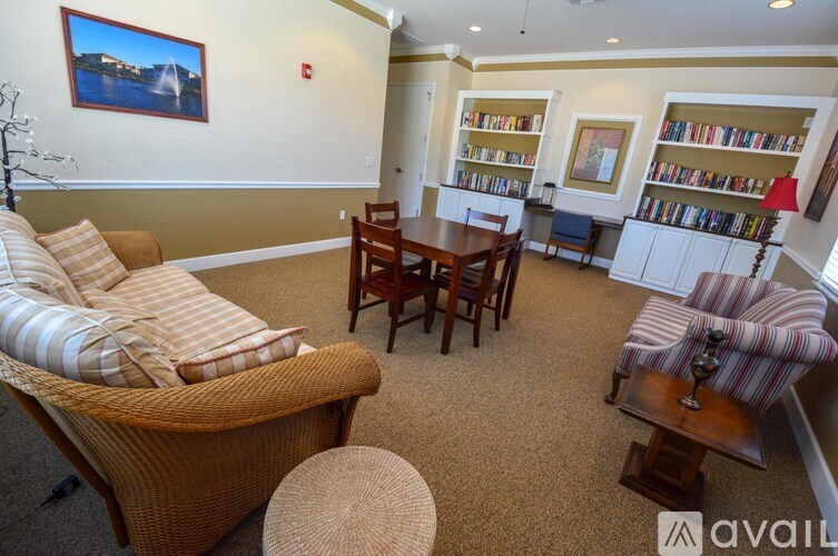 A living room with a couch, chairs, and a bookshelf.