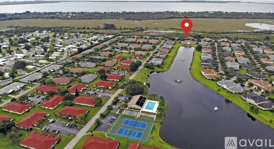 A bird's eye view of a residential area with a red pin marking a specific house.