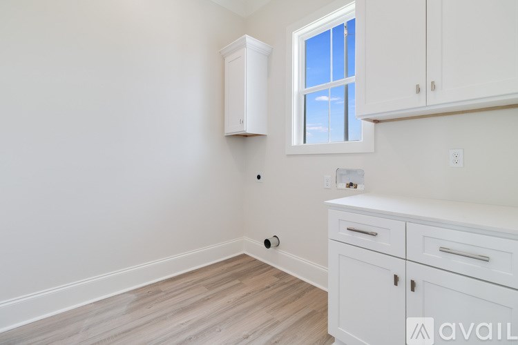 A kitchen with white cabinets and a window.