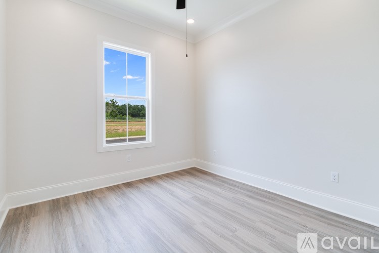 A room with a window showing a field outside.
