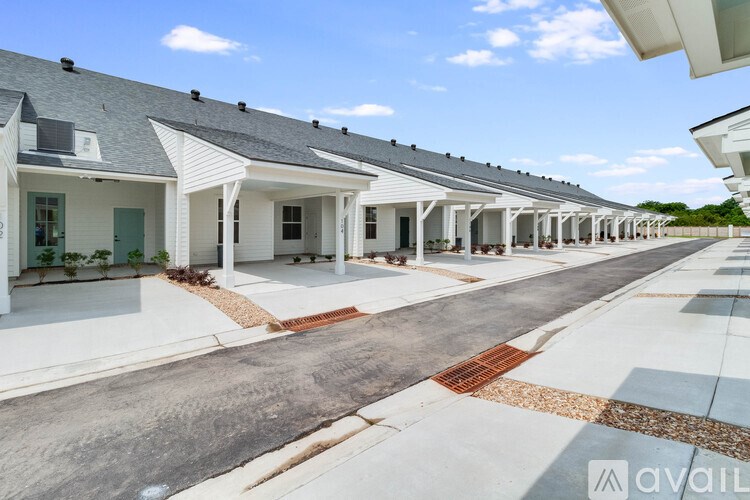 A row of white houses with a clear blue sky above them.