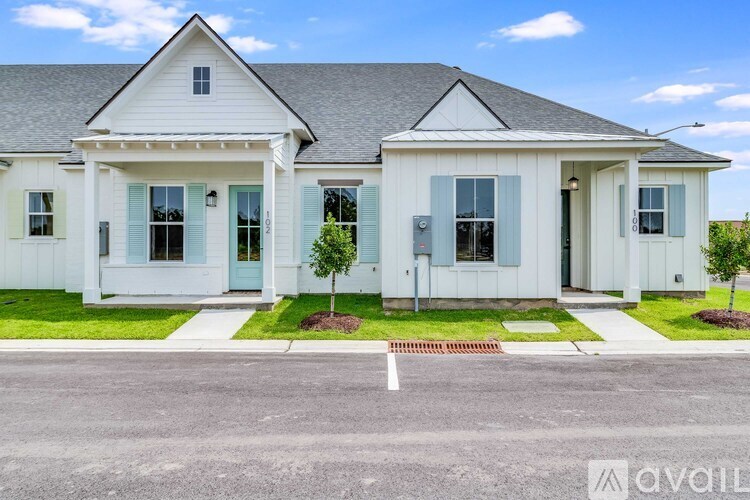 A white house with a blue door and shutters is available for sale.