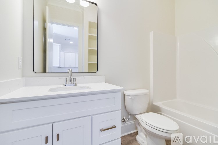 A white bathroom with a sink, toilet, and bathtub.