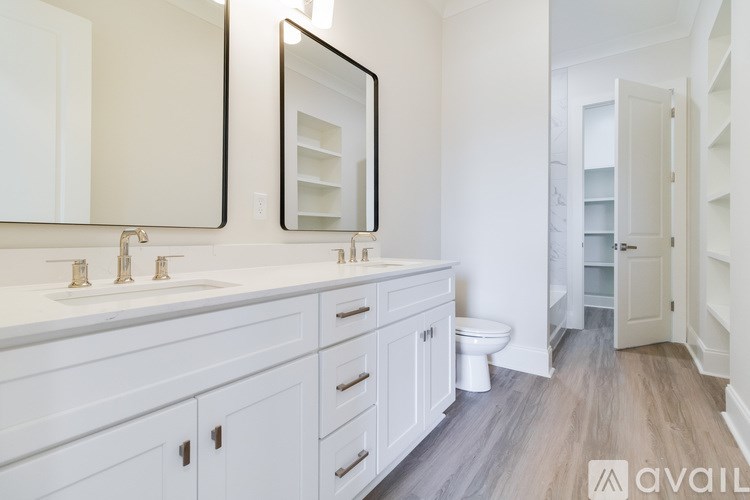 A bathroom with a white vanity and a large mirror.