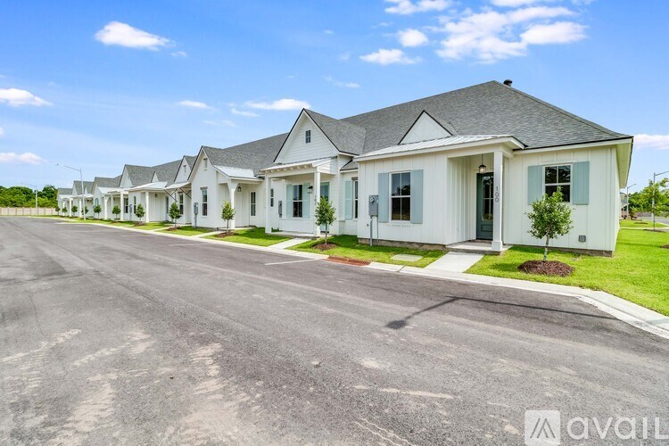 A row of white houses with a road in front.