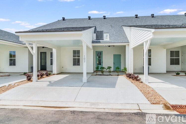 A white house with a green door and windows.