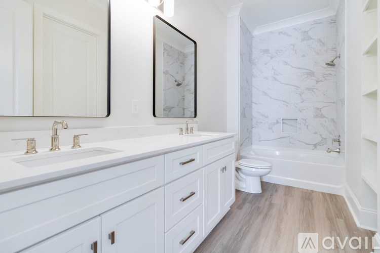 A bathroom with a marble wallpaper and a wooden floor.