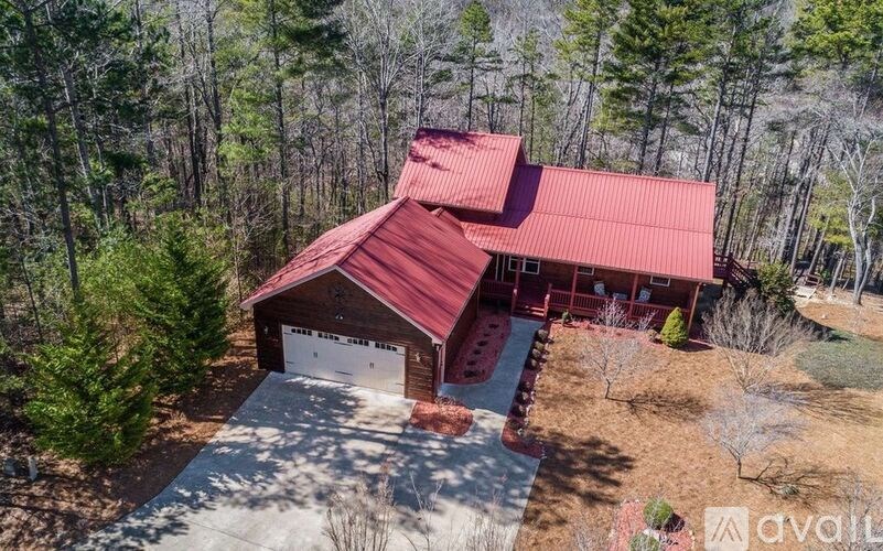 A house with a red roof is surrounded by trees.